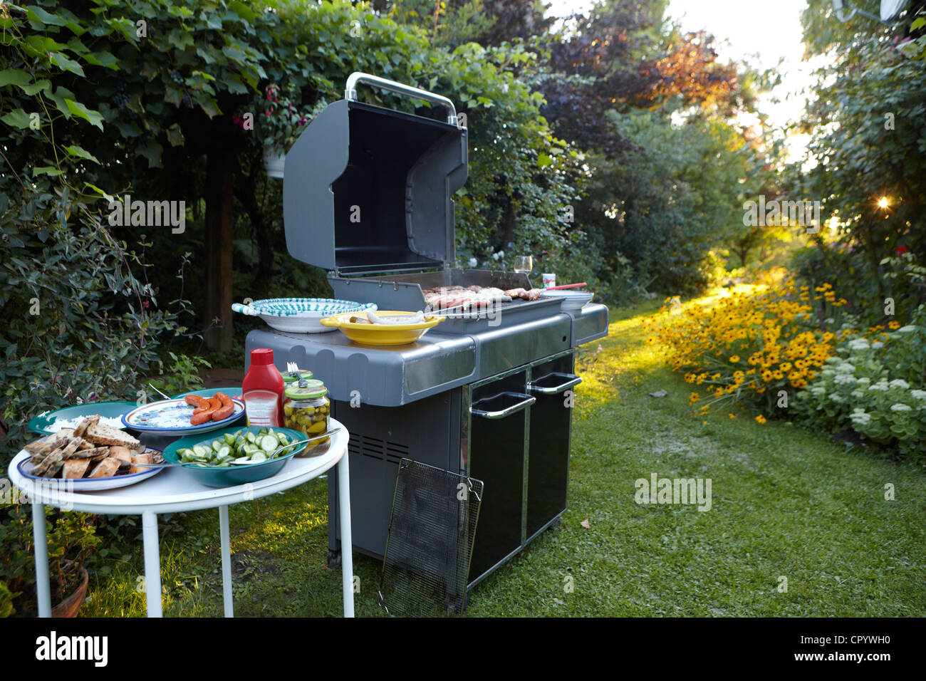 bbq area with large barbecue salads and side dishes in the garden CPYWH0