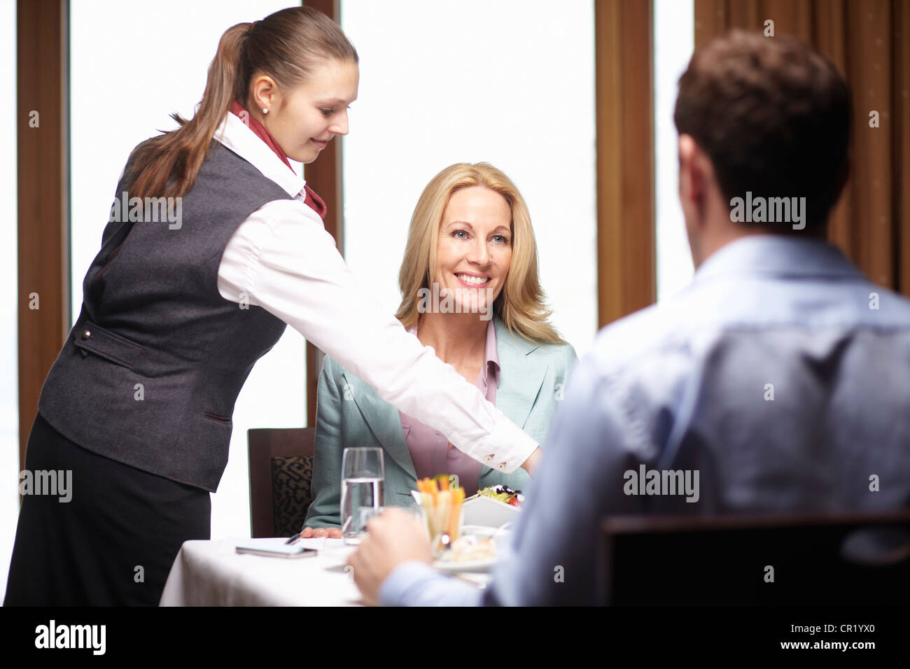 Waitress serving business people in cafe Stock Photo, Royalty Free