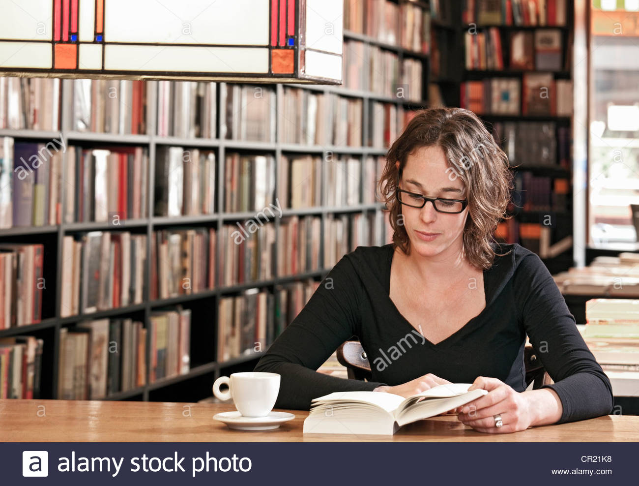 woman-reading-in-bookstore-cafe-CR21K8.j