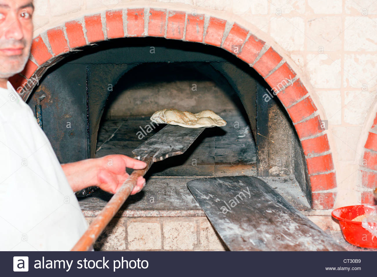 Baking bread in a traditional Turkish brick oven, Tonoz Beach Hotel