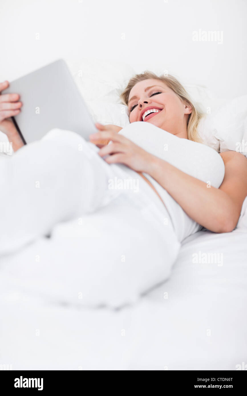 Blonde Laughing While Using An Ebook Reader Stock Photo Alamy