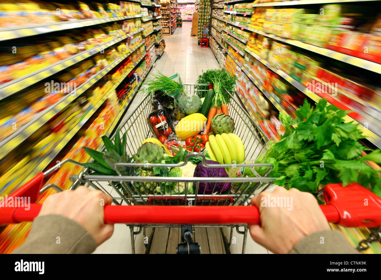 Food hall, full shopping trolley is pushed through a hallway with Stock