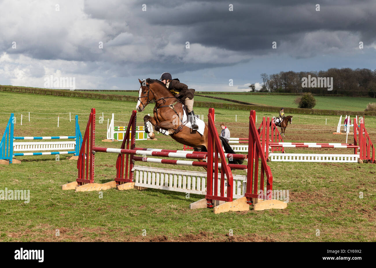 RIDERS AND HORSES JUMPING FENCES AT A SHOW JUMPING EVENT IN CHEPSTOW