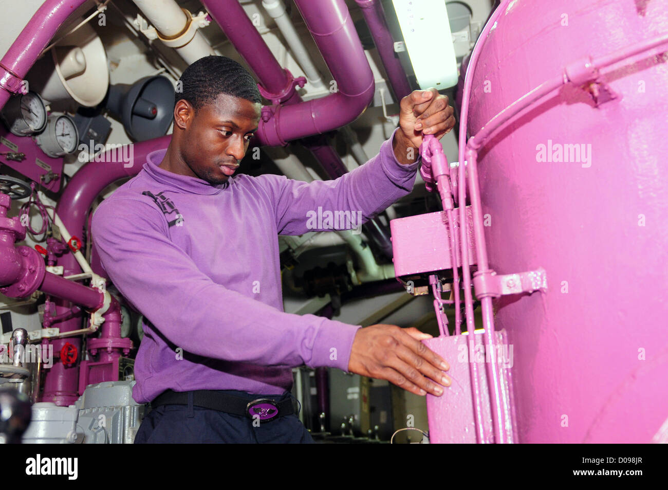 Aviation Boatswain's Mate (Fuel) 3rd Class Steven Hinton adjusts a