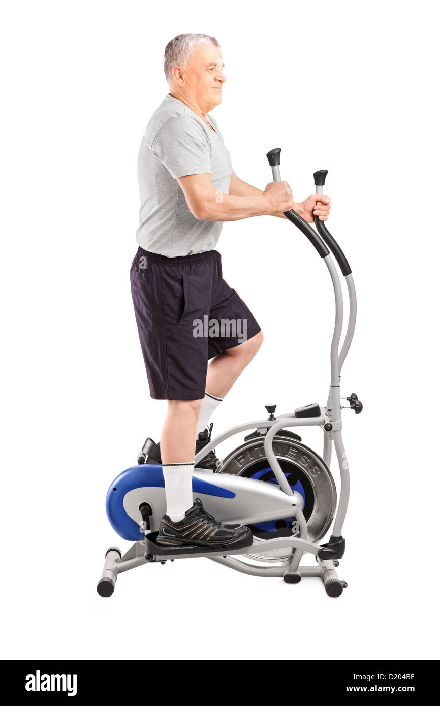 Full Length Portrait Of A Mature Sporty Man Exercising On A Cross Trainer Isolated On White