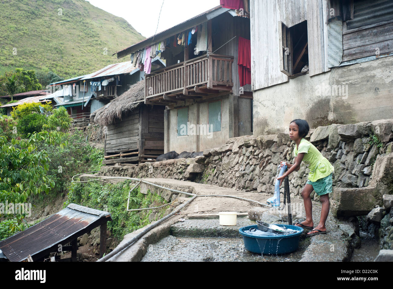Girl washing clothes in the small village in Philippines. About 12
