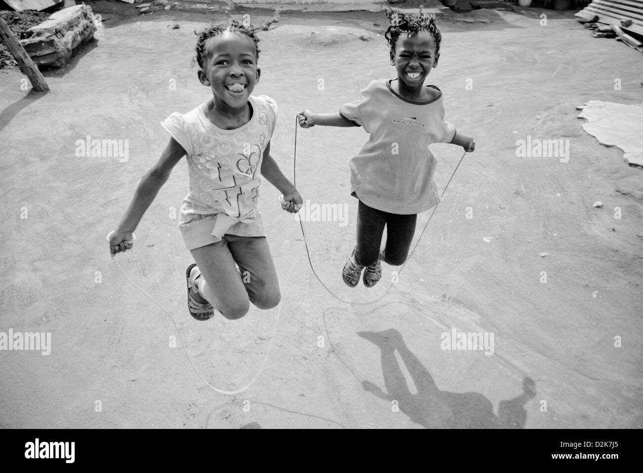 Kids playing on jumping rope in Soweto township in Johannesburg Stock