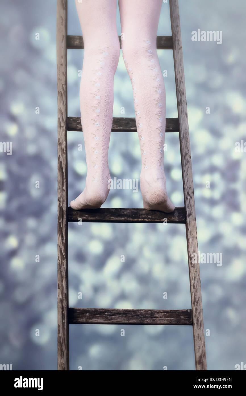 a girl in stockings on an old wooden ladder Stockfoto, Lizenzfreies
