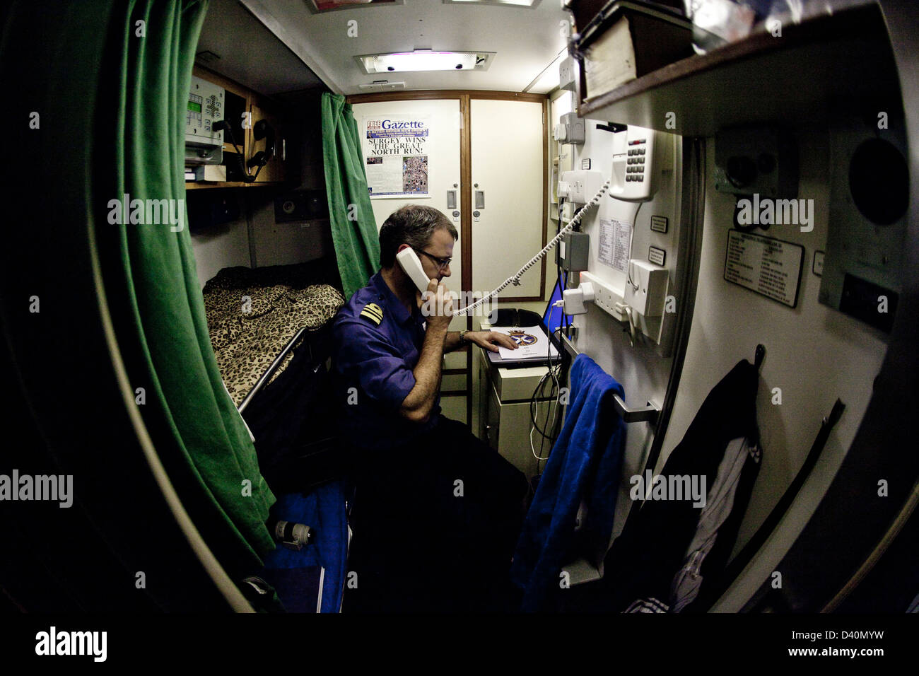 Crew man on phone in bunk room of Nuclear Submarine HMS Talent Stock