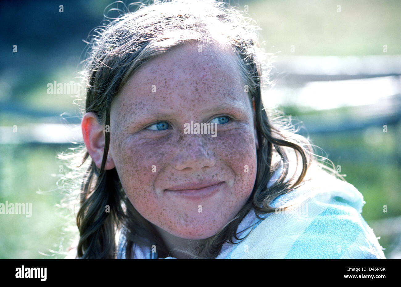 Freckles cover the face of a young German girl who spends summers in the sun ...