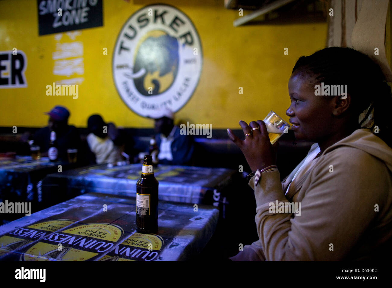 Kenyans drink beer in a bar during happy hour in a Nairobi slum Stock
