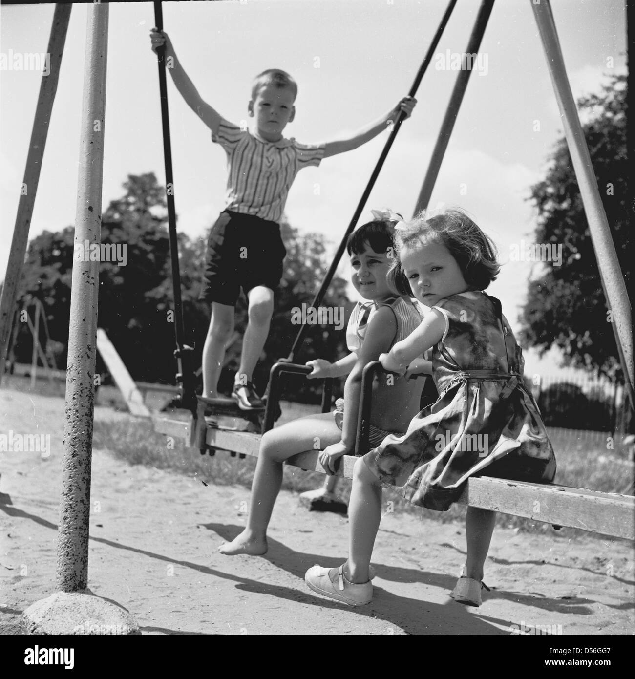 Historical 1950sthree Small Children Play Outside On A Swing Boy
