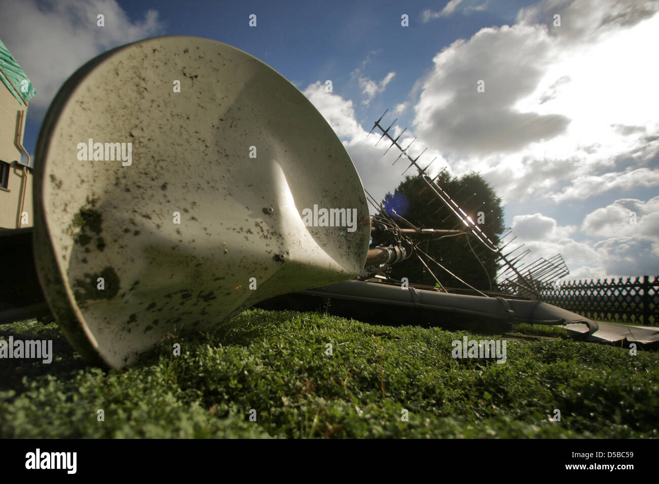 A satellite dish has been blown off the roof and into the garden by a