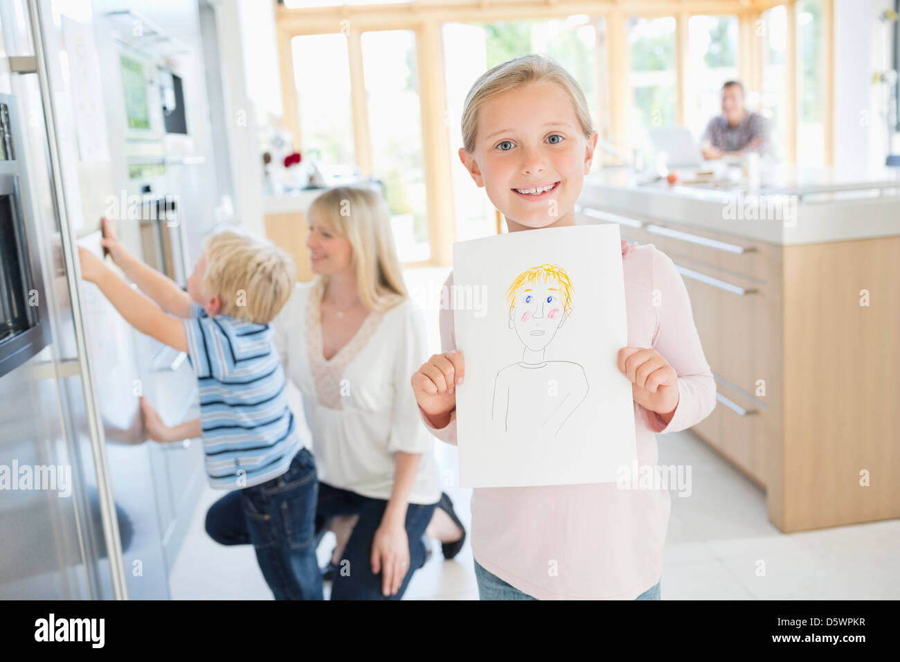 Girl showing off drawing in kitchen Stock Photo, Royalty Free Girl showing off drawing in kitchen Stock Photo, Royalty Free
