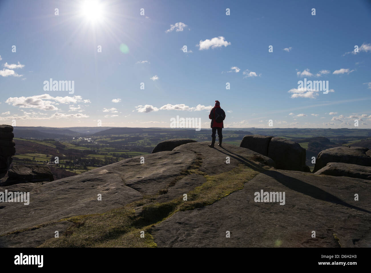Single Person Standing On Cliff Edge Looking Out At The Scenery In Derbyshire England Single Person Standing On Cliff Edge Looking Out At The Scenery In Derbyshire England