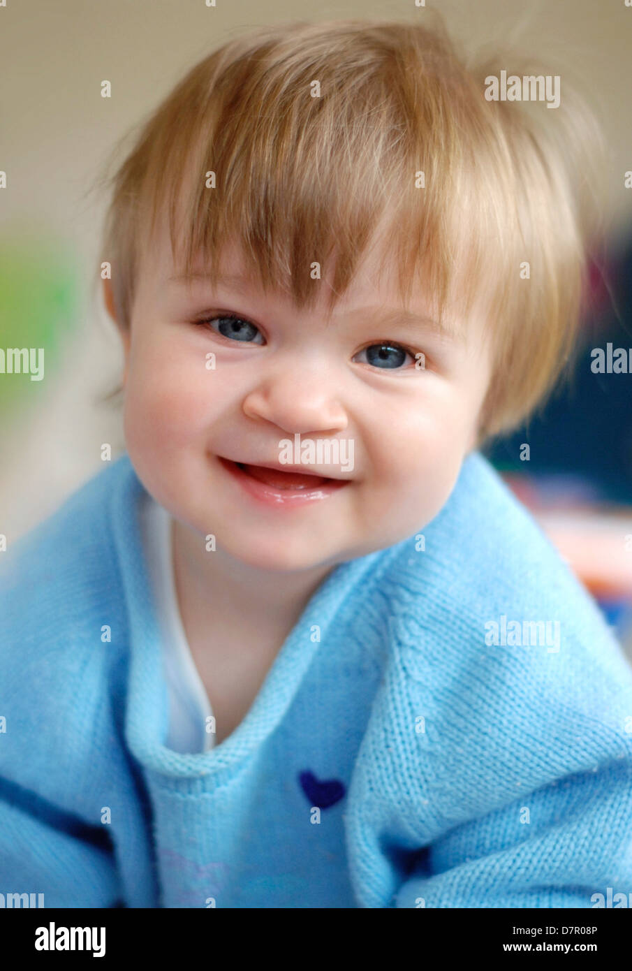 Cute Baby Girl With Long Hair Smiling At Camera Stock Photo