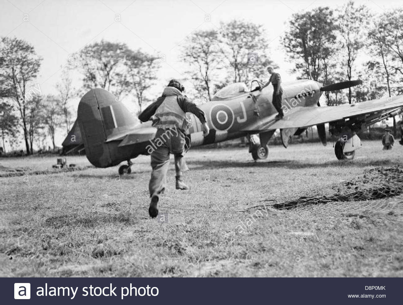 A pilot of No. 175 Squadron RAF scrambles to his waiting Hawker Stock