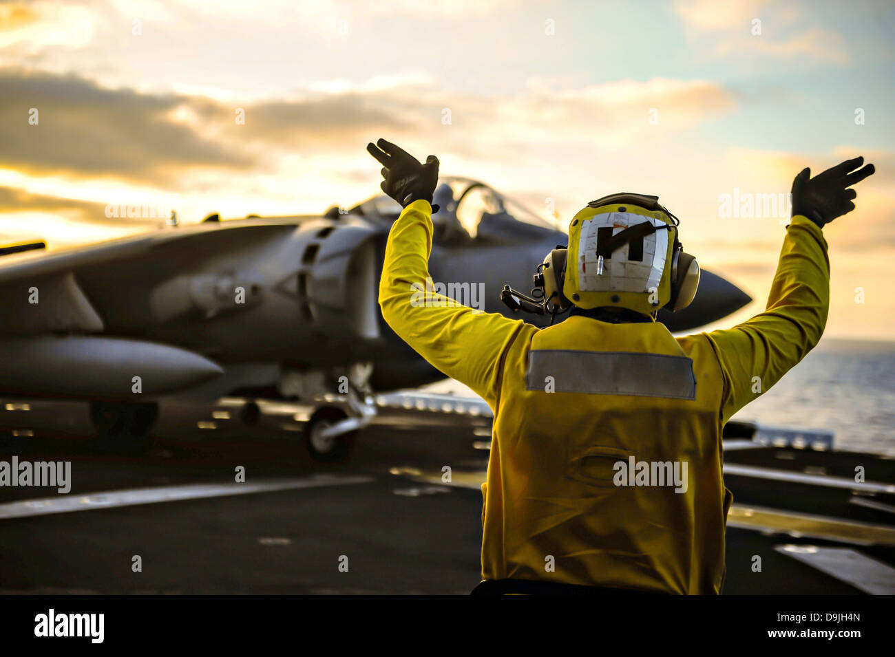 A US Navy deck crew directs a Marine Corp AV8B Harrier fighter jet