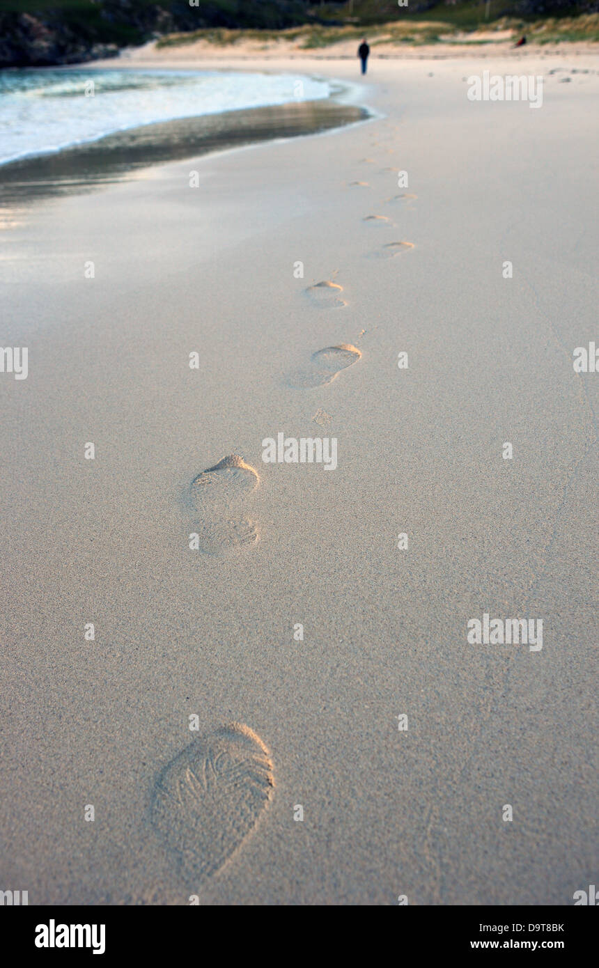footsteps-on-a-beach-leading-to-a-man-in