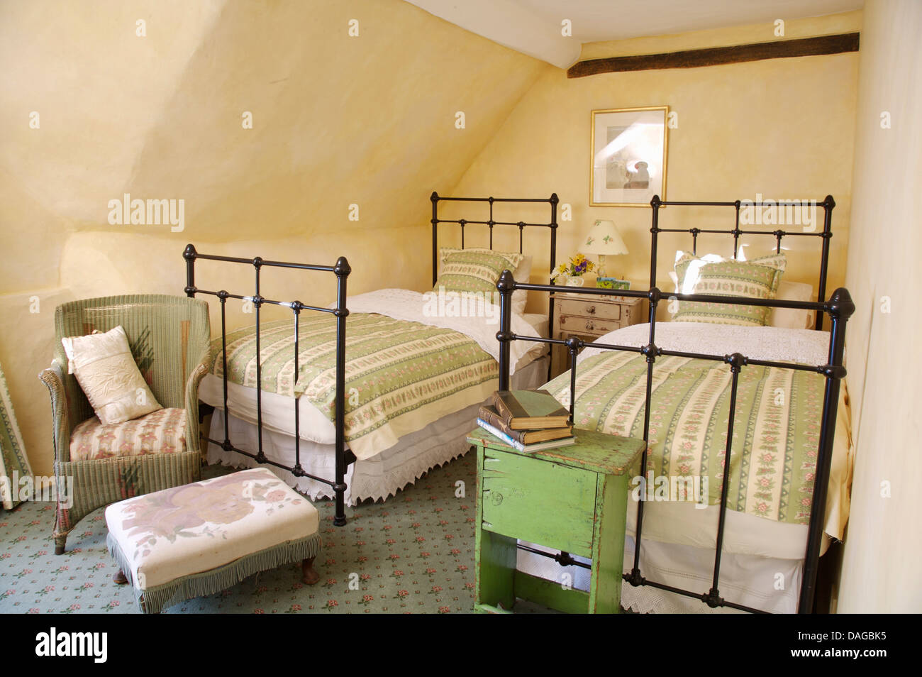 Wrought iron twin beds with green throws in attic bedroom with ... Wrought iron twin beds with green throws in attic bedroom with ...