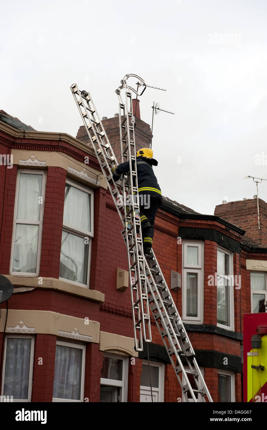 Firefighter Carrying Roof Ladder up 135 Ladder UK Stock Photo, Royalty