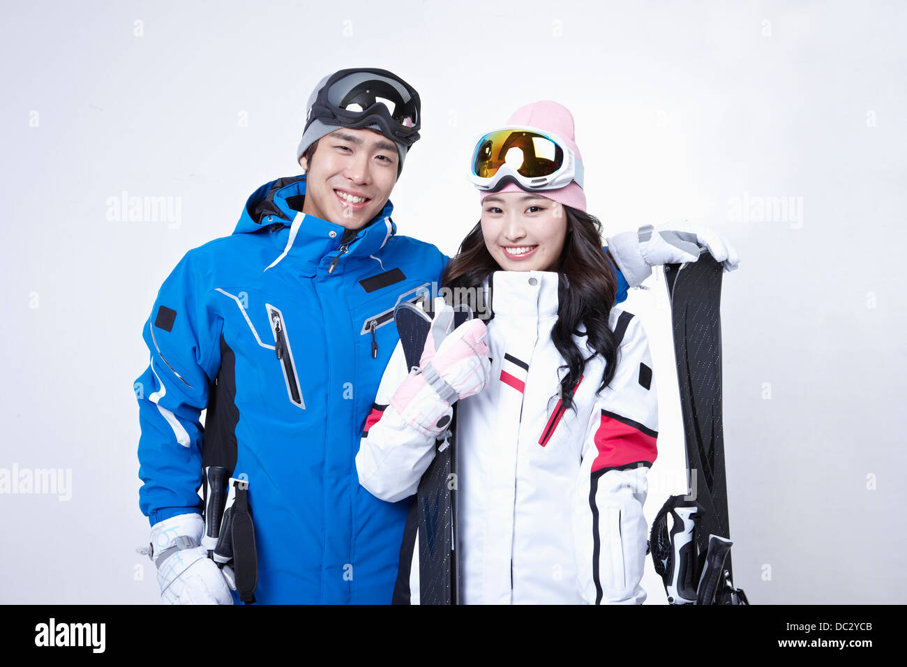a couple in ski outfit posing in white background
