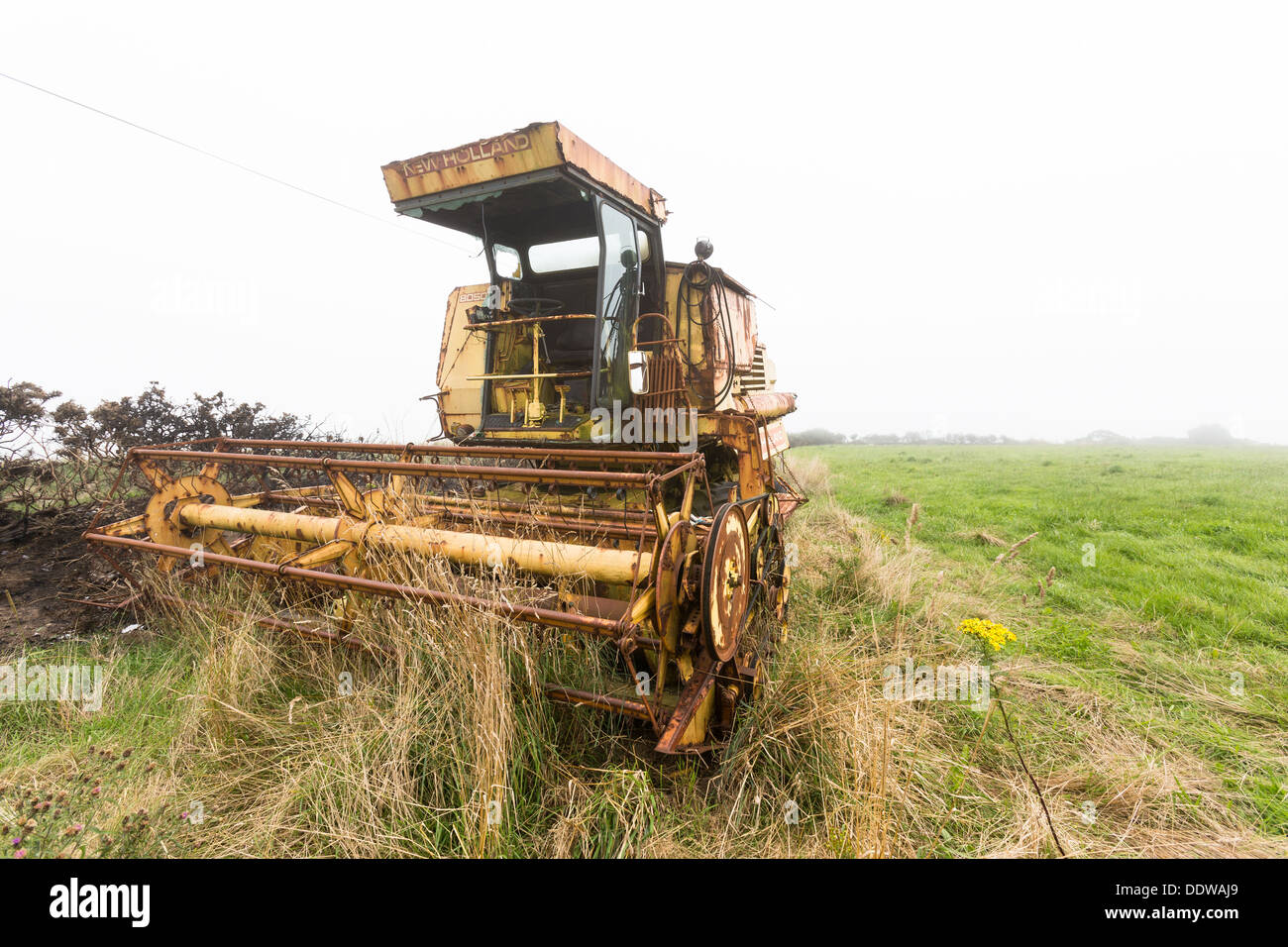 Abandoned vandalised rusty New Holland combine harvester, mid Wales