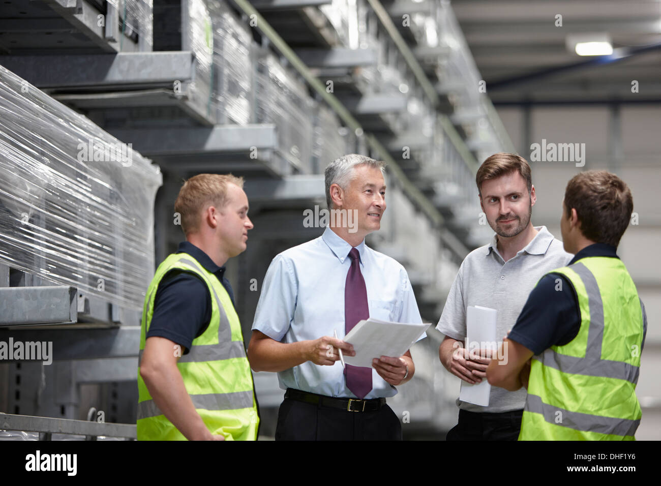 Warehouse workers and manager meeting in engineering warehouse Stock