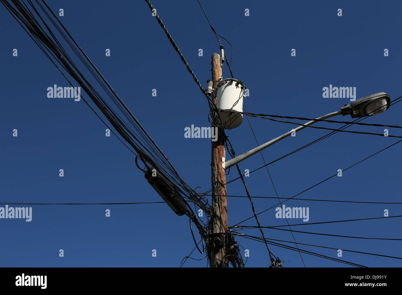 Power lines, transformer and hanging metal lamp post attached to Stock