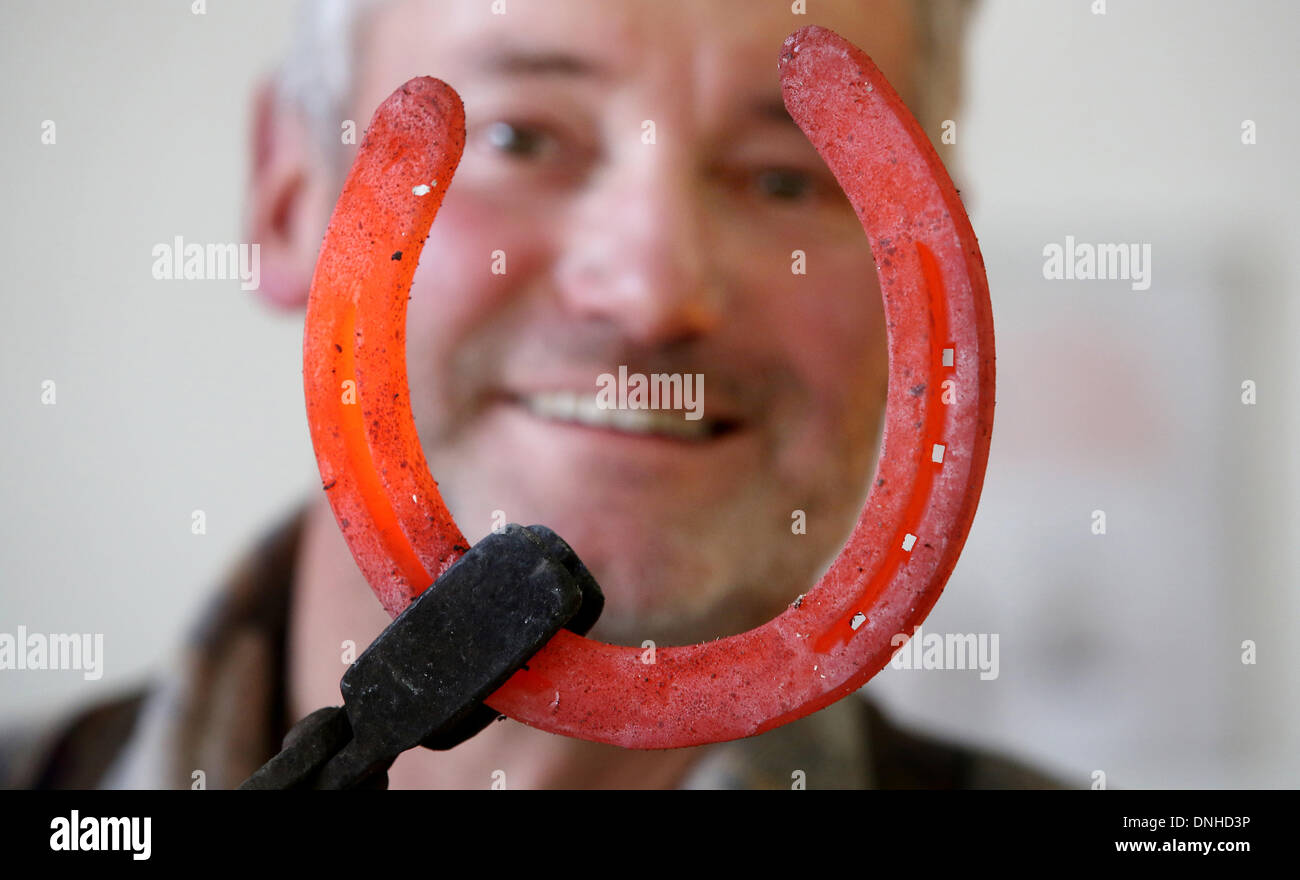 Photo: <b>Thomas Warnack</b>/dpa/Alamy Live News - kanzach-germany-30th-dec-2013-farrier-charly-maurer-holds-a-red-glowing-DNHD3P