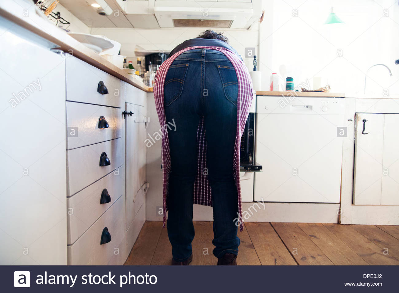 old woman bending over kitchen table