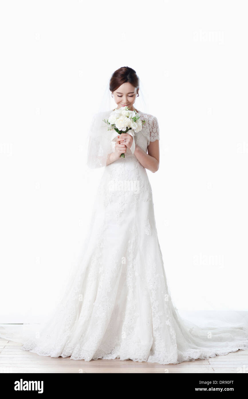 Full Shot Of A Woman In Wedding Dress Holding Flower Bouquet Stock