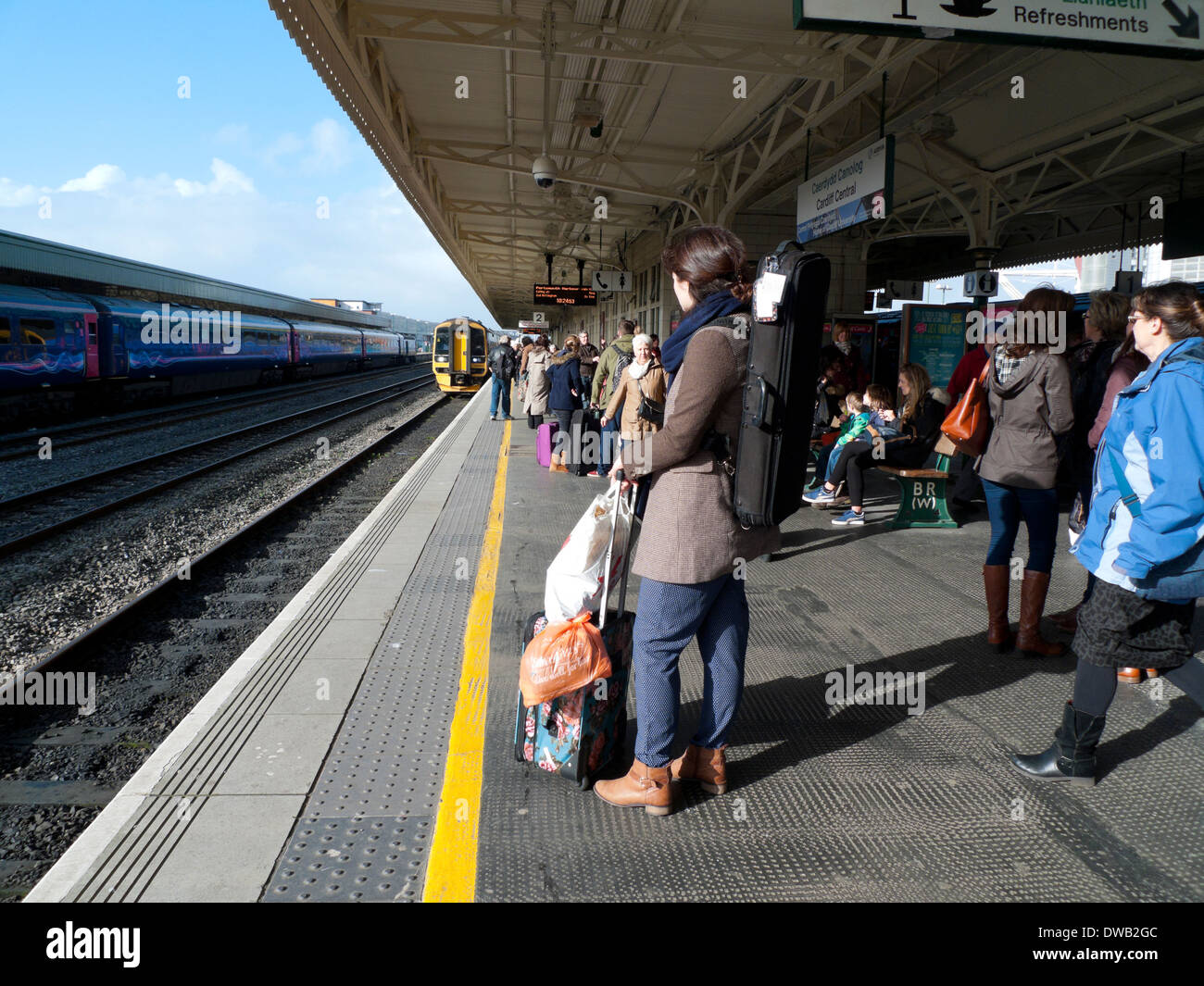 Rail passengers waiting for train on the platform at Cardiff Railway