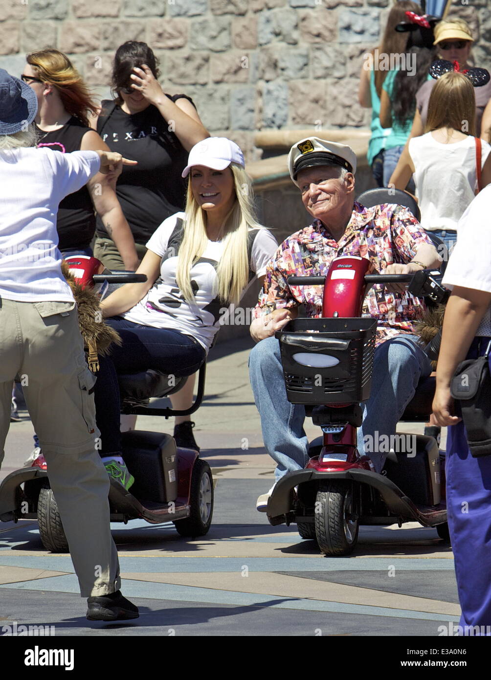 hugh-hefner-and-crystal-hefner-ride-mobility-scooters-through-disneyland-E3A0N6.jpg
