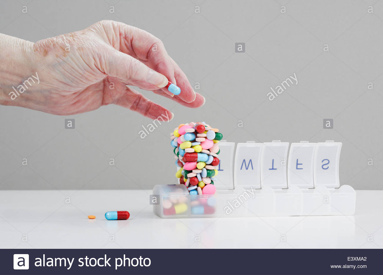 Senior-Caucasian-man-stacking-pills-in-p