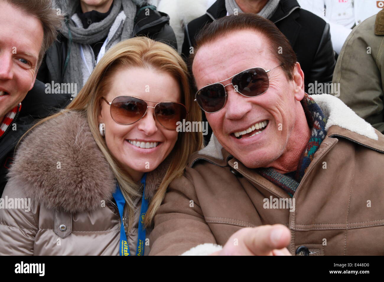Arnold Schwarzenegger and girlfriend Heather Milligan sitting in the