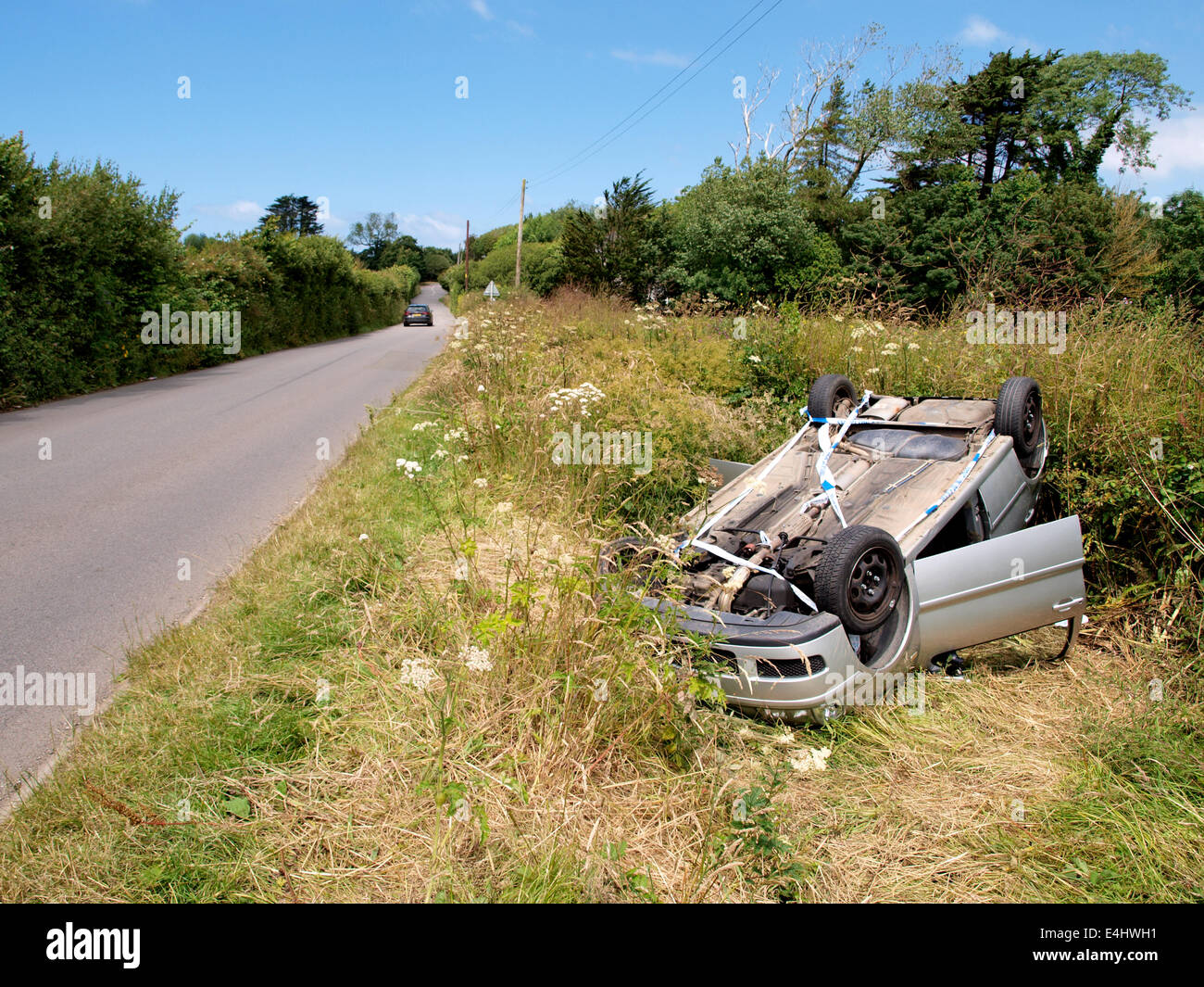 Crashed car upside down in a ditch beside the road, Westward Ho! Stock