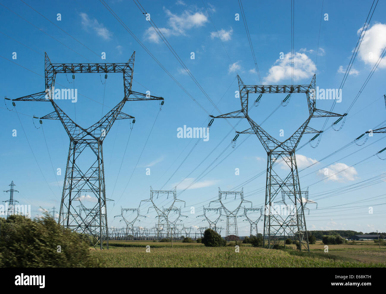 Pylons carrying high voltage power lines march across the French Stock