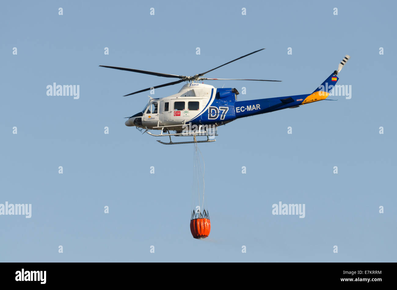 Fire rescue heavy helicopter with water bucket, water bombing a Stock