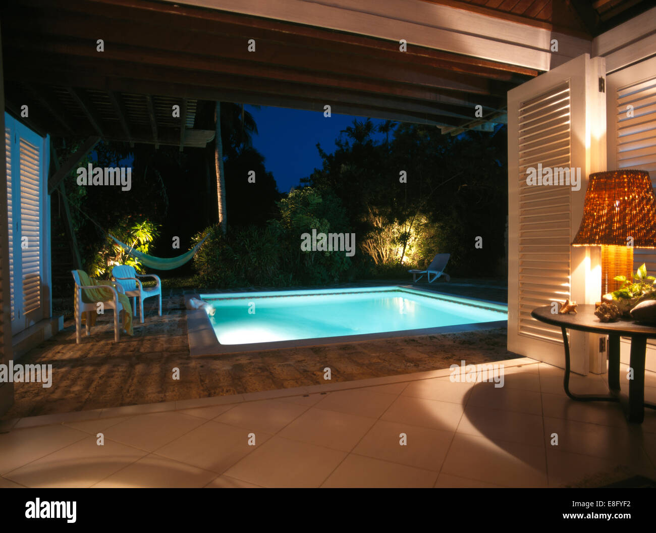 House Under Pool lighting around under-lit swimming pool in garden of modern house House Under Pool lighting around under-lit swimming pool in garden of modern house