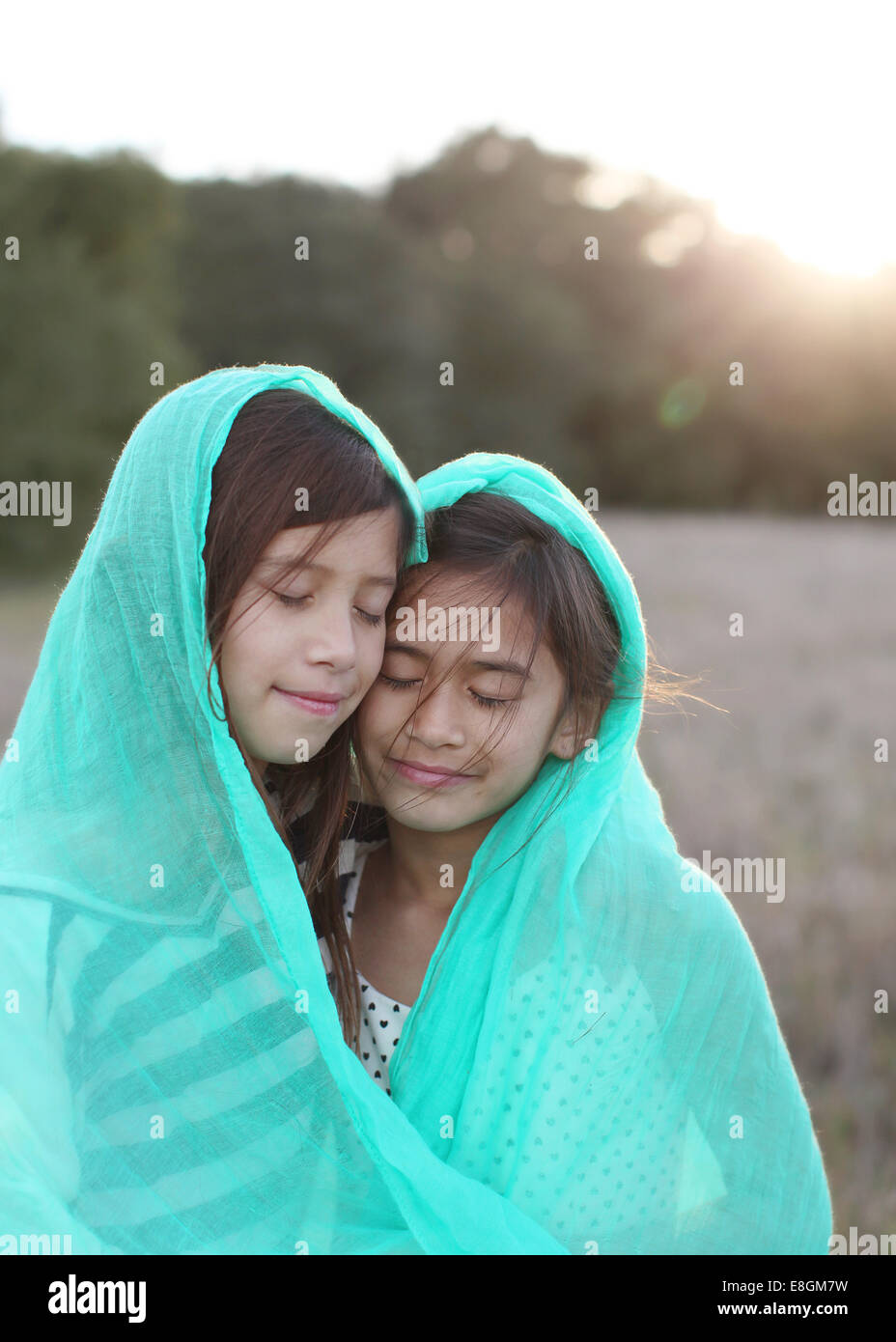 Two girls wrapped in a blanket Stockfoto, Lizenzfreies Bild 74125853