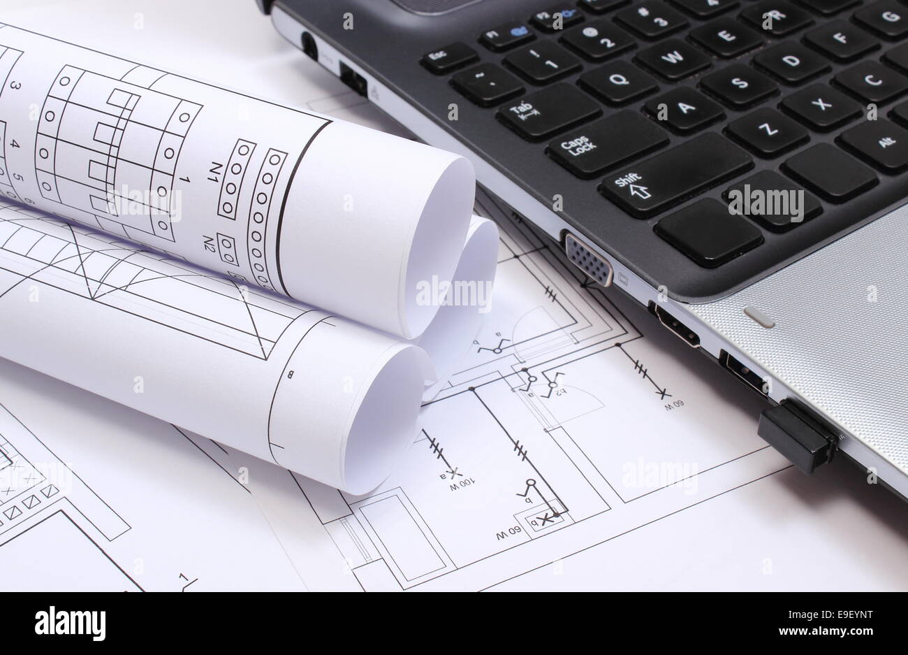 rolls of electrical diagrams with construction drawings of house and laptop drawings and accessories for the projects engineer rolls of electrical diagrams with construction drawings of house and laptop drawings and accessories for the projects engineer