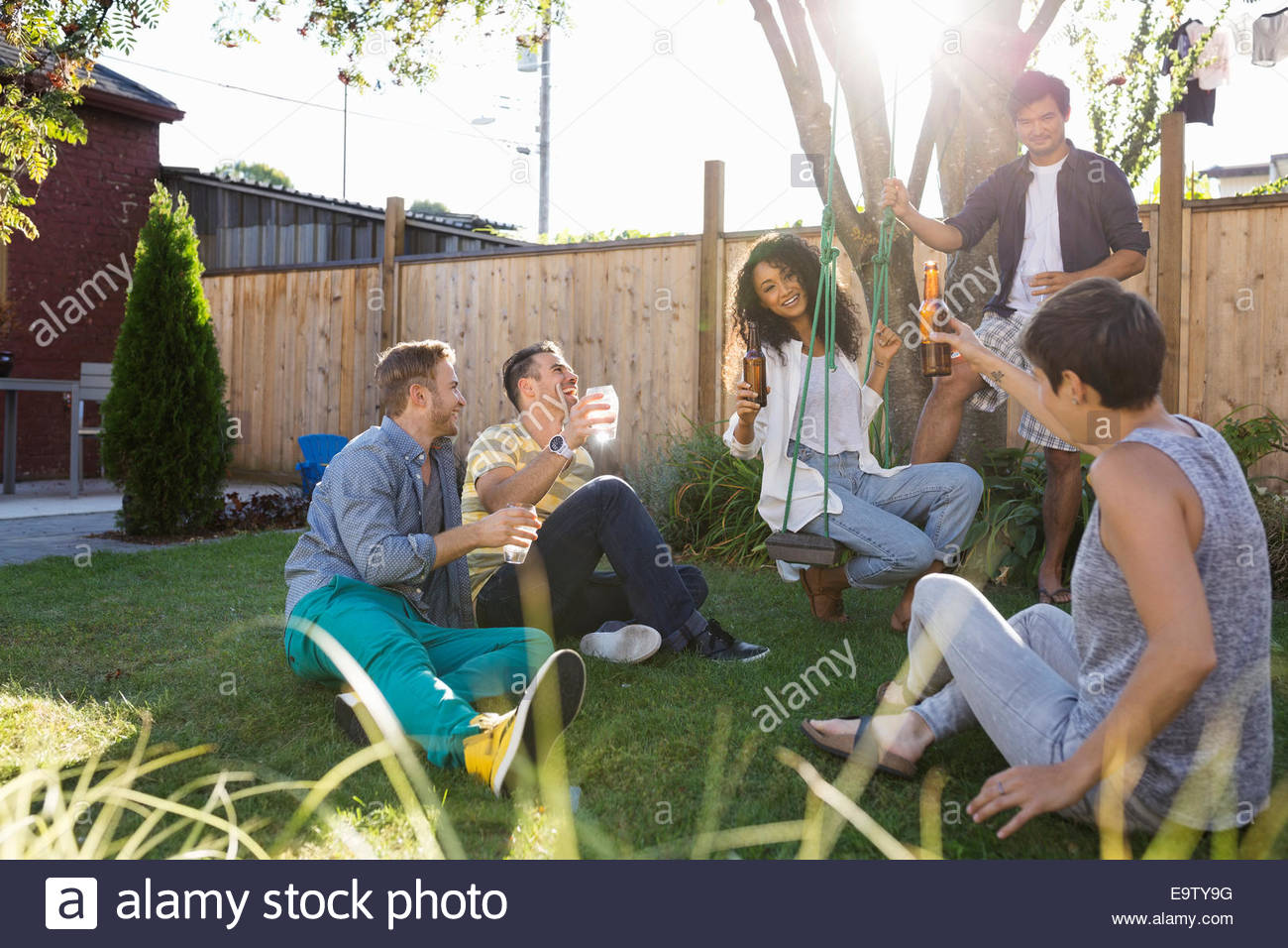 Friends Drinking And Hanging Out At Backyard Barbecue Stock Photo