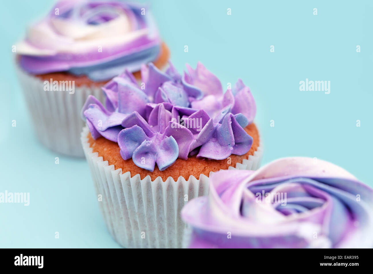 delicious sweet buffet with magenta cupcakes on cyan background delicious sweet buffet with magenta cupcakes on cyan background