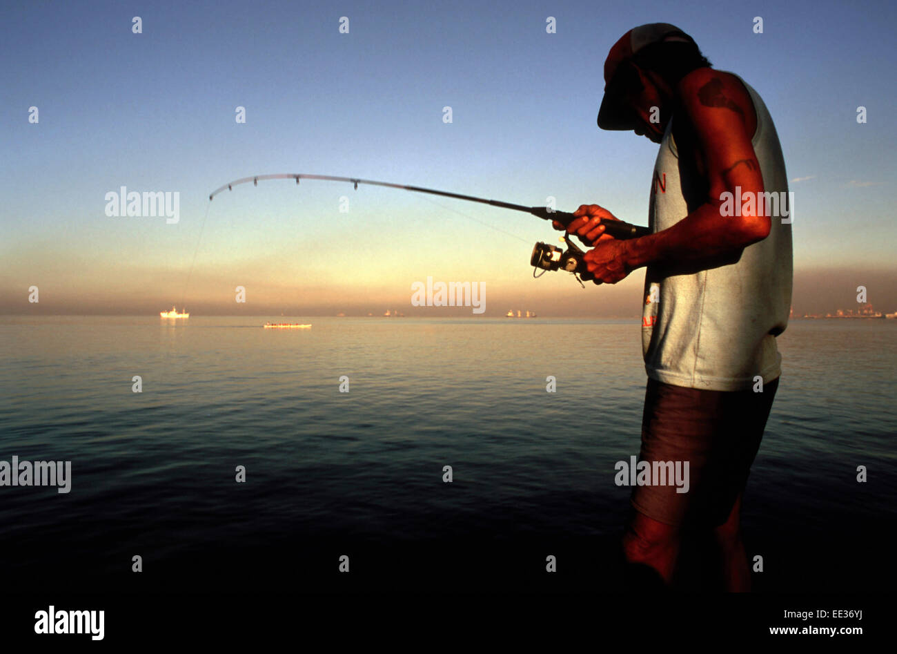 Fisherman fishing in Manila Bay. Roxas Boulevard. Manila Stock Photo