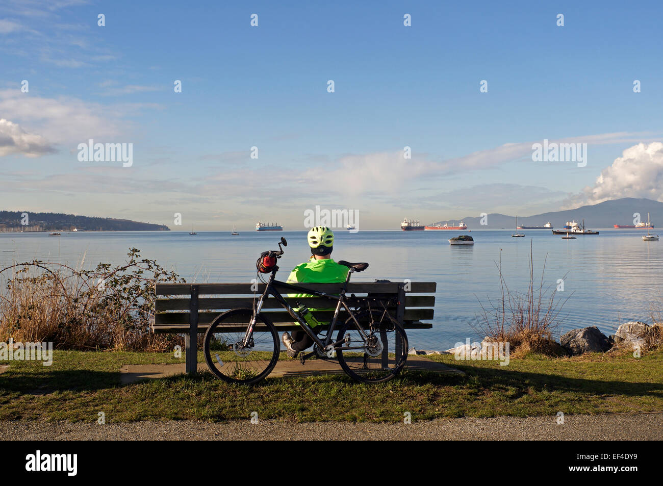 male-cyclist-sitting-on-a-park-bench-ove