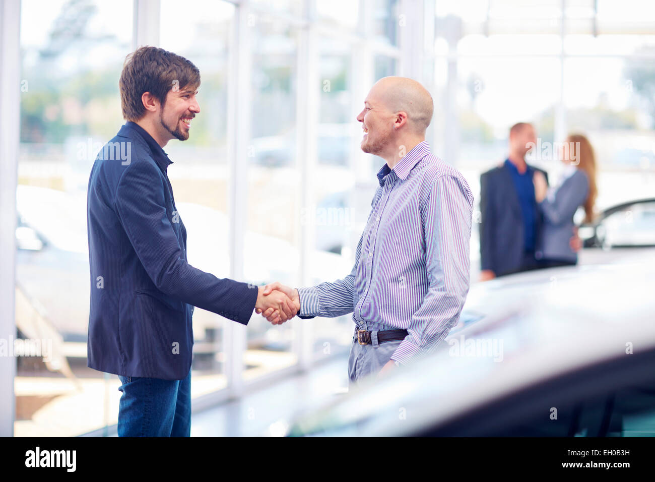 Car dealer and client shaking hands Stock Photo, Royalty Free Image