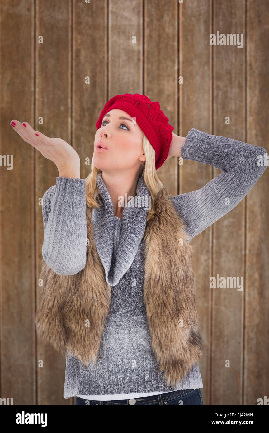 Composite Image Of Blonde In Winter Clothes Blowing Kiss Stock Photo