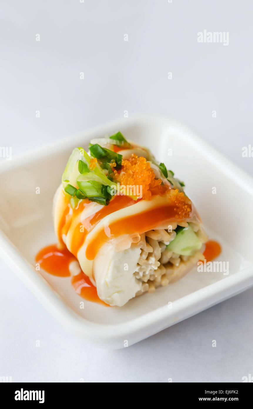 Salmon roll sushi with shrimp egg on top in white dish Stock Photo