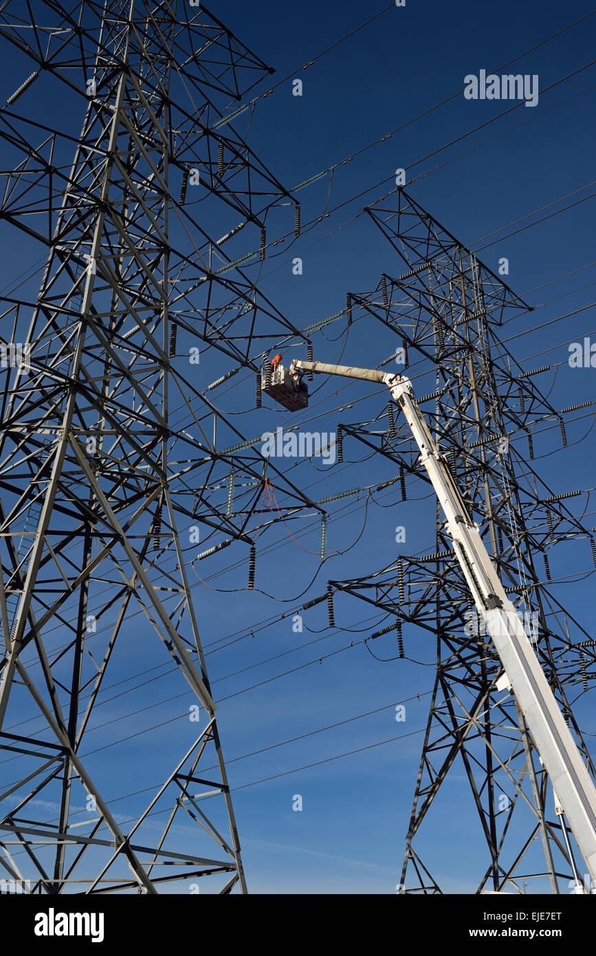Hydro linemen on boom lift working to replace suspension insulators Stock Photo, Royalty Free